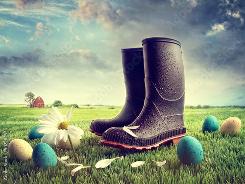 Photo: Rubber boots with easter eggs on grass Rubber boots with easter eggs on grass