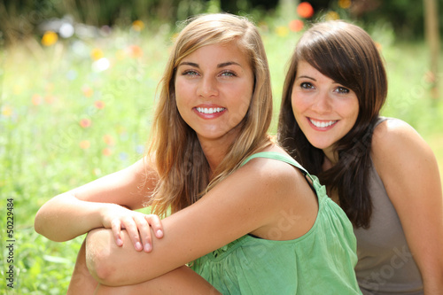 Photo: Girls sitting in a field Girls sitting in a field