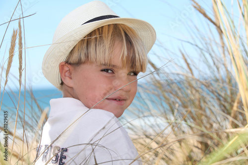 Photo: Blond boy surrounded by reeds Blond boy surrounded by reeds