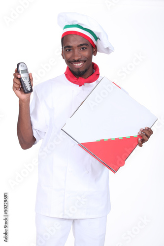 Photo: Chef with a telephone and a take away pizza box Chef with a telephone and a take away pizza box