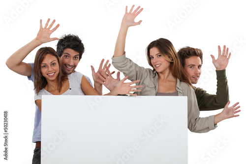 Photo: Enthusiastic friends with a board left blank for your message Enthusiastic friends with a board left blank for your message