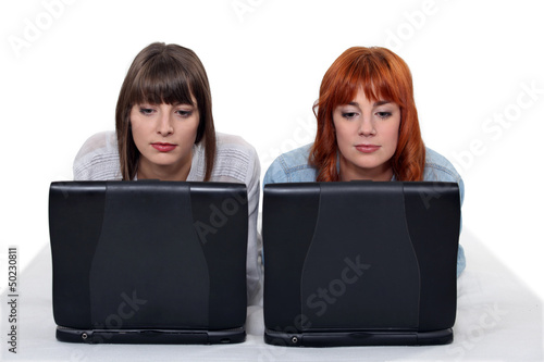 Photo: Two young women side by side with laptops Two young women side by side with laptops