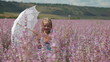 Little girl with lace parasol on meadow
