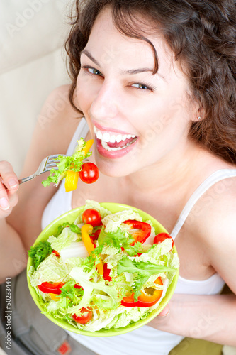 Photo: Diet. Beautiful Young Woman Eating Vegetable Salad Diet. Beautiful Young Woman Eating Vegetable Salad