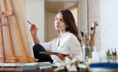 Photo: woman paints picture on canvas woman paints picture on canvas