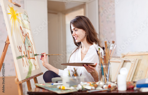 Photo: woman paints landscape on canvas woman paints landscape on canvas
