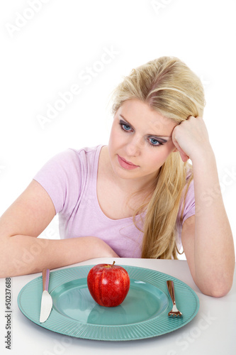 Photo: Junge blonde Frau frustriert bei Diät mit rotem Apfel Junge blonde Frau frustriert bei Diät mit rotem Apfel