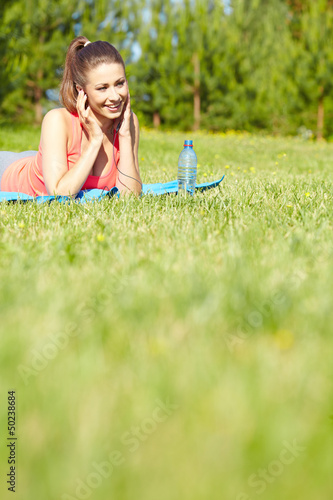 Photo: Outdoor workout woman. Fitness woman runner relaxing drinking wa Outdoor workout woman. Fitness woman runner relaxing drinking wa