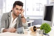 Photo: Desperate businessman sitting at desk in disorder Desperate businessman sitting at desk in disorder