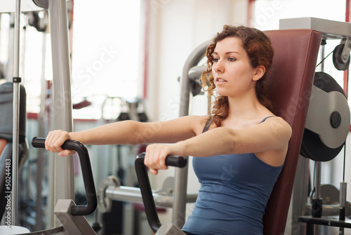 Photo: Young woman training in the gym. Young woman training in the gym.