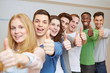 Jubelnde Studenten halten Daumen hoch