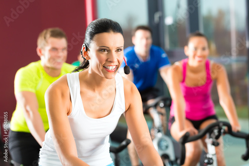 Photo: Group of people spinning on bikes in gym Group of people spinning on bikes in gym