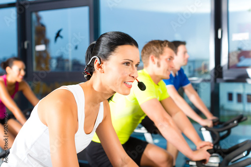 Photo: Group of people spinning on bikes in gym Group of people spinning on bikes in gym