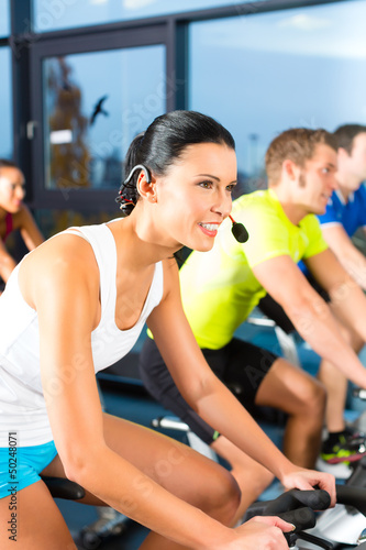 Photo: Group of people spinning on bikes in gym Group of people spinning on bikes in gym