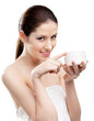 Woman putting on lifting cream from white container
