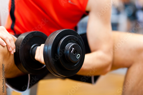 Photo: Young athlete lifting weights in the gym Young athlete lifting weights in the gym