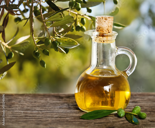  Olive oil and olive branch on the wooden table