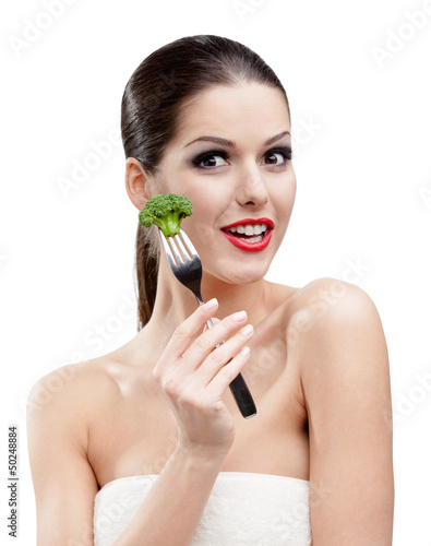 Photo: Woman with red lipstick eating broccoli on the stainless fork Woman with red lipstick eating broccoli on the stainless fork