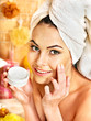 Woman applying moisturizer.