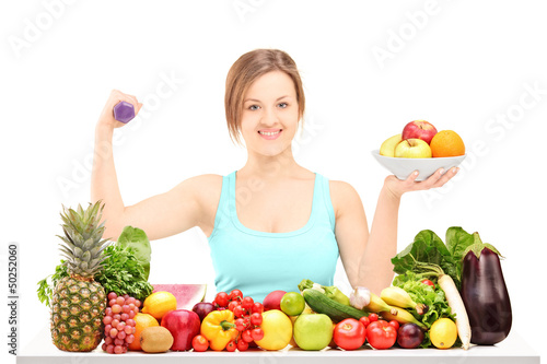 Photo: Beautiful young female holding a dumbbell and posing behind a pi Beautiful young female holding a dumbbell and posing behind a pi