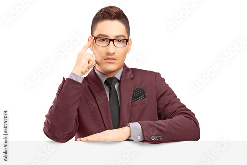 Photo: Handsome young man posing behind a blank panel Handsome young man posing behind a blank panel