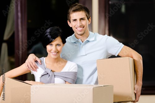 Photo: Happy couple carrying cardboard packages Happy couple carrying cardboard packages