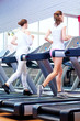 Photo: Two young sporty women run on machine Two young sporty women run on machine