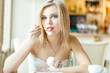 A woman in the restaurant is eating ice cream