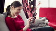 Young woman with tablet computer sitting on sofa
