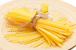 Foto: Pasta bunch composition on a wooden plate, closeup view Pasta bunch composition on a wooden plate, closeup view