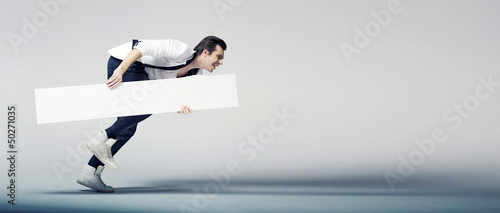 Photo: Elegant man running with a white board Elegant man running with a white board