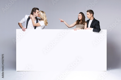Photo: Surprised friends staring at kissing couple Surprised friends staring at kissing couple
