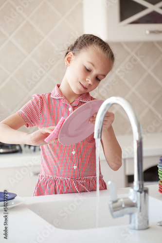 Photo: Little girl washing the dishes Little girl washing the dishes
