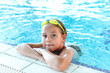 Happy girl with goggles in swimming pool