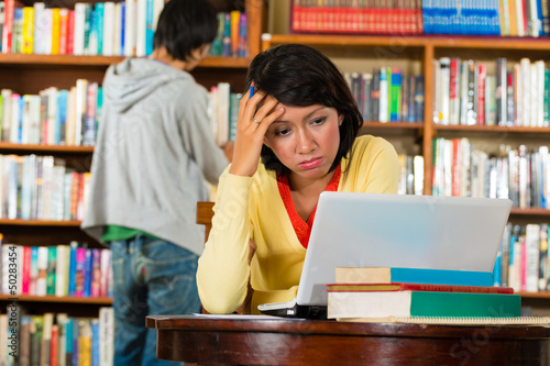Photo: Young Girl in library with laptop Young Girl in library with laptop