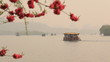 Boats float on the lake. In the foreground blossoming cherry.