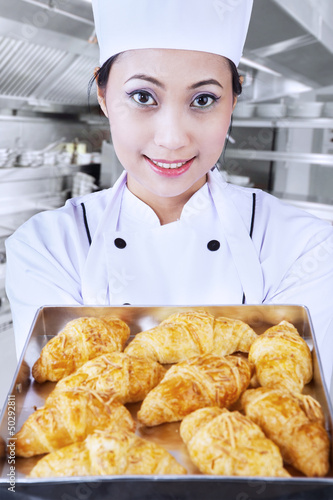 Photo: Baker brings croissant in kitchen Baker brings croissant in kitchen