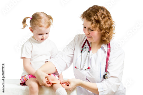 Photo: Girl with scratched knee. Doctor curing kid isolated on white. Girl with scratched knee. Doctor curing kid isolated on white.