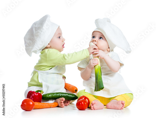 Photo: children boy and girl wearing a chef hat with healthy food vege children boy and girl wearing a chef hat with healthy food vege