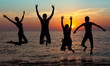 silhouette of jumping people on sunset background