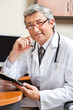 Doctor Sitting At Desk In Clinic