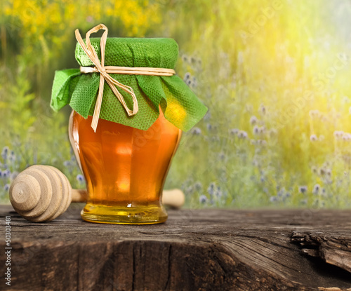 Photo: Honey jar on the wooden table Honey jar on the wooden table