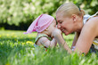 Young smiling mother and her baby-girl rub noses