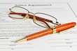 Contract with glasses and wooden pen ready to be signed