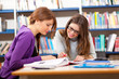 Two pretty college students in a libray