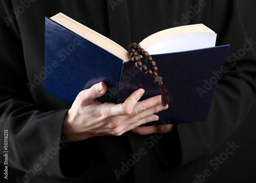 Photo: Priest reading from the holy bible, close up Priest reading from the holy bible, close up