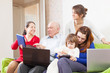 family enjoys in livingroom room with few laptops