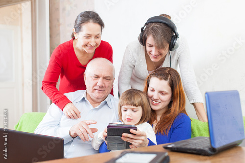 Photo: Happy people uses various electronic devices in home Happy people uses various electronic devices in home