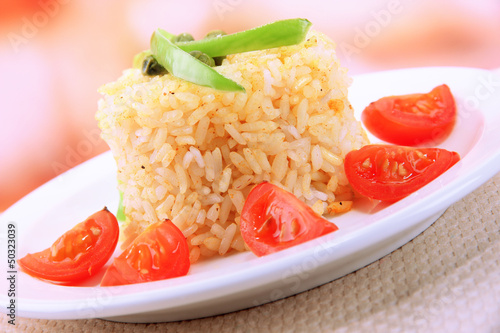Photo: Delicious risotto with vegetables on table in cafe Delicious risotto with vegetables on table in cafe