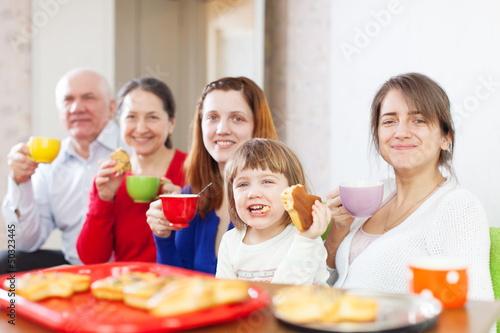 Photo: Happy family drinks tea with cakes Happy family drinks tea with cakes